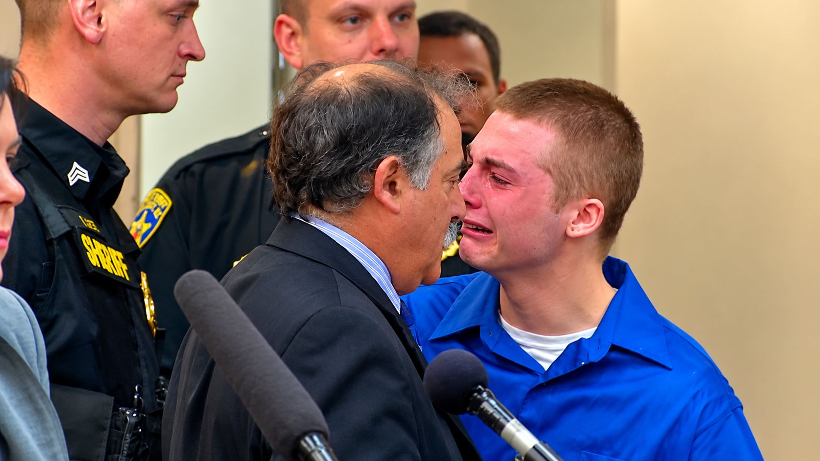Deputies and an attorney escort a tearful young man through the courthouse after his sentencing